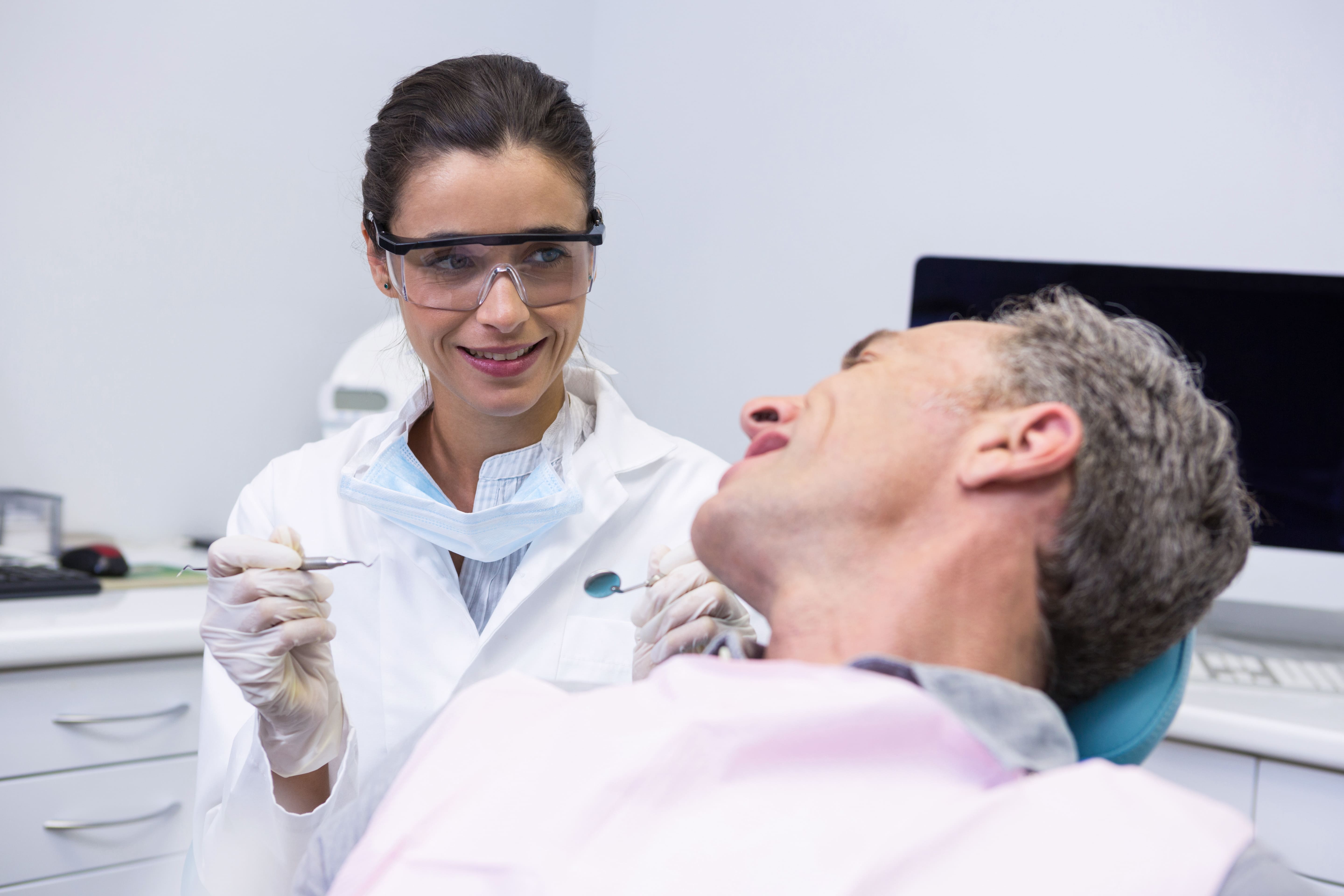 Dentista realizando revisión preventiva a paciente